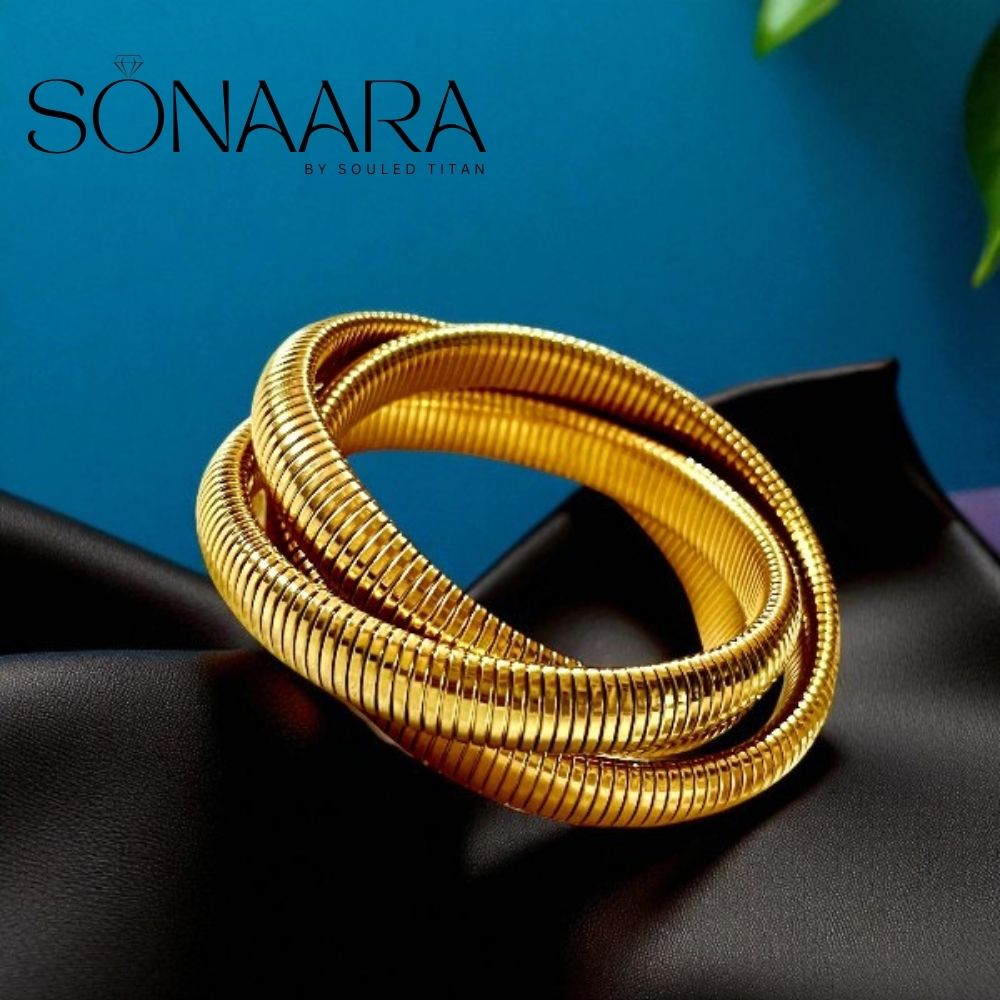 Gold 3 Layered Wide Bracelet For Women on a black surface with a blue background, branded 'Sonaara'.