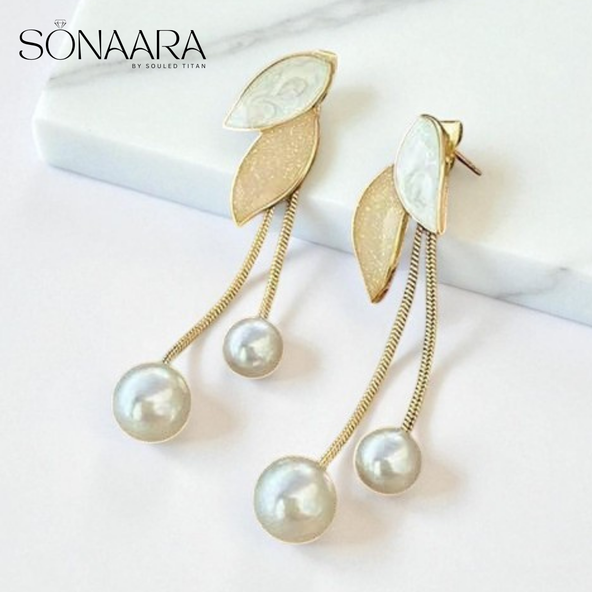 Pearl earrings with gold leaves on a white background, branded 'Sonaara'.