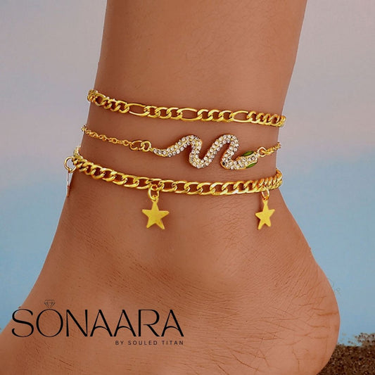 Gold anklets with star and wave designs on a person's ankle, branded 'Sonaara'.