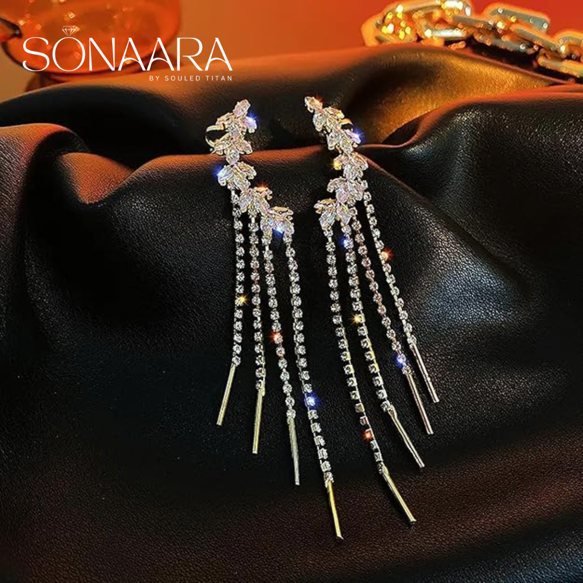 Elegant tassel drop earrings with dangling crystals on a dark fabric background, branded 'Sonaara'.