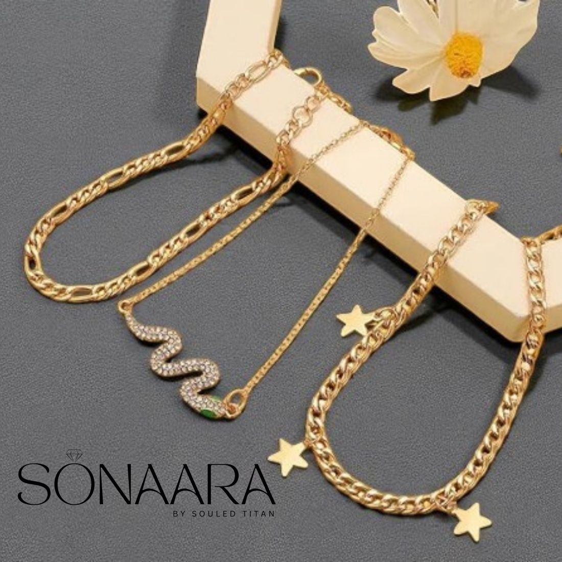 Gold chain anklets for women with star details on a wooden stand with a gray background, featuring the brand 'SONAARA'.