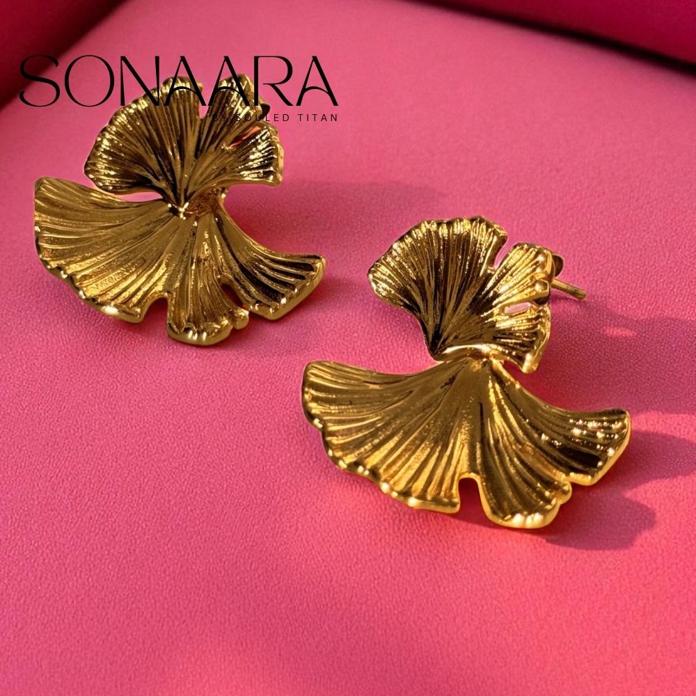 Gold leaf-shaped earrings on a pink background with 'Sonaara' branding.