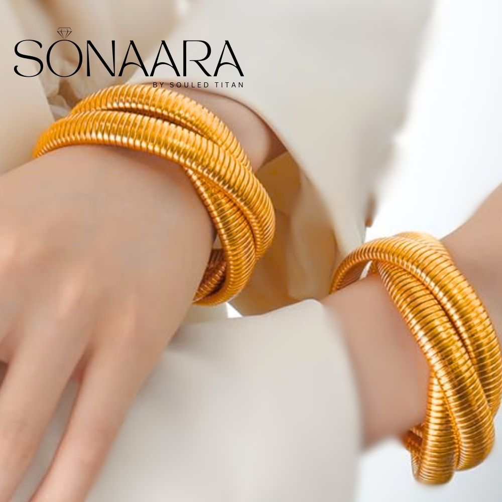 Gold bangles on a woman's hand with 'Sonaara' branding.