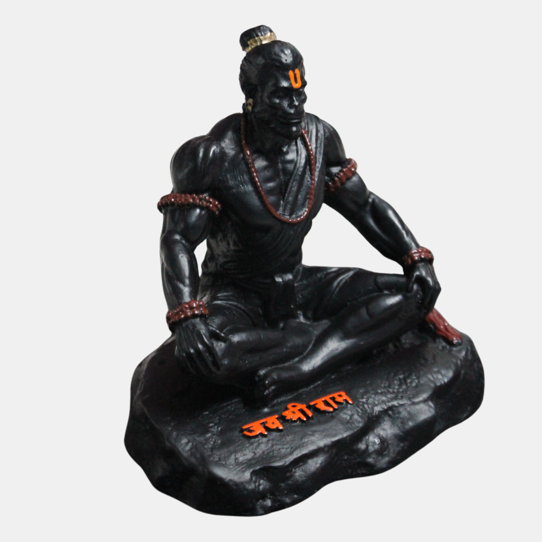 Black statue of a seated Hanuamn statue with red accents on a white background
