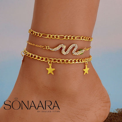 Gold anklets with star and wave designs on a person's ankle, branded 'Sonaara'.