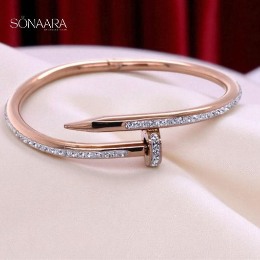Rose gold bracelet with clear stones on a white surface, branded 'Sonaara'.