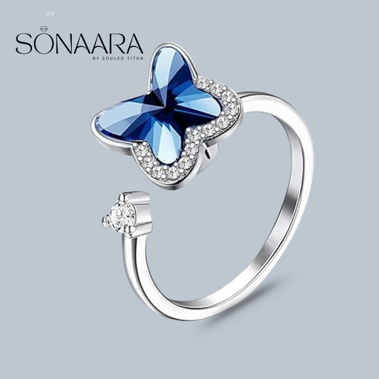 Silver ring with a blue butterfly-shaped gem and 'Sonaara' branding on a light gray background
