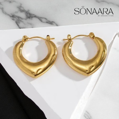 Gold Kaan bali earrings on a white surface with 'Sonaara' branding.