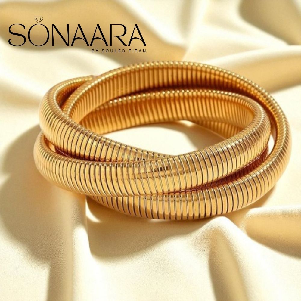 Gold bangles on a beige fabric background with 'Sonaara' branding.