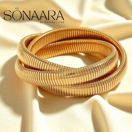 Gold bangles on a beige fabric background with 'Sonaara' branding.