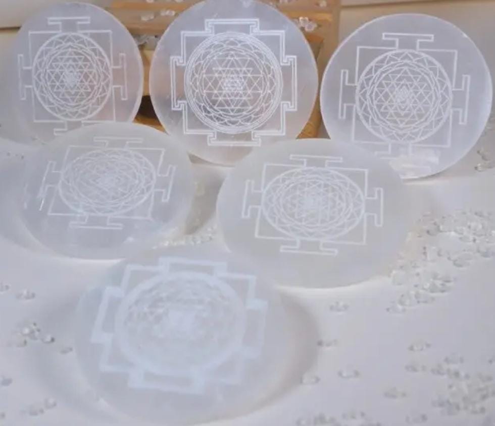 Set of six translucent selenite plate with Shree Yantra designed on a light background