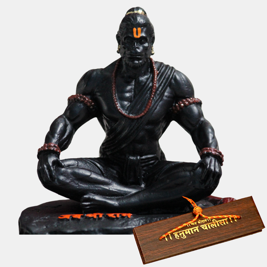 Black Hanuman statue of a meditating figure with a wooden Hanuman Chalisa Book on a white background