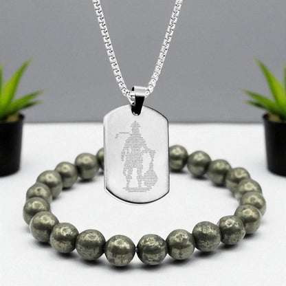 Silver Hanuman Chalisa necklace with engraved Hanuman Chalisa on a white surface with green plants in the background and Raw pyrite