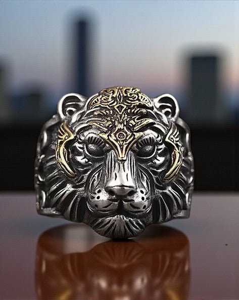 stainless steel ring with tiger head on a reflective surface with a blurred cityscape background