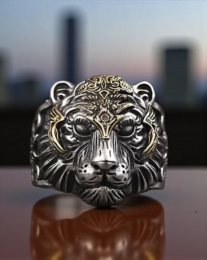 stainless steel ring with tiger head on a reflective surface with a blurred cityscape background