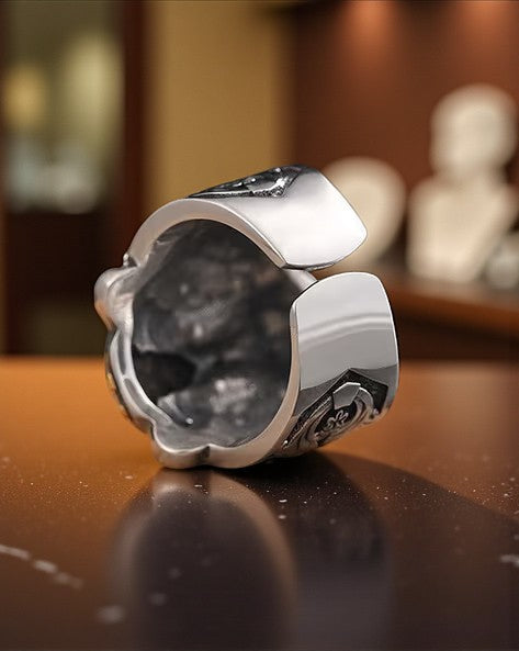 stainless steel ring with black stone on a reflective surface